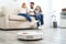 Family resting while robotic vacuum cleaner doing its work