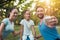 The family rests in the park after playing sports. A man does selfie with his family