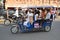A family rides in Tuk Tuk Taxi on the streets of Jaipur