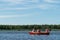 Family rides a wooden boat on the lake in good weather on vacation, active holidays