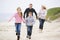 Family running at beach holding hands