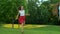 Family running in green field. Parents and kids playing with ball outdoors