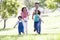 Family running outdoors holding hands and smiling