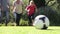 Family Running To Kick Football In Garden