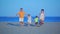 Family runs to sea on the beach