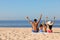 Family on sandy beach near sea, back view. Summer holidays