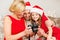 Family in santa helper hats looking at pictires