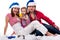 Family in Santa\'s hat sitting in artificial snow