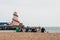 A family sat on the pebble beach at southsea with south parade pier and a helter