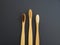Family set of three eco natural biodegradable bamboo toothbrushes on the dark background. Zero waste concept