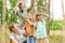 Family shielding eyes while exploring forest during vacation