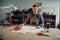 In a family shoe shop a young apprentice works with paper to create a pattern for shoes