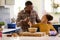 Family Shot With Father And Daughter Baking At Home In Kitchen Mixing Ingredients In Bowl