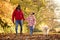 Family Shot With Father And Daughter Walking Pet Golden Retriever Dog In Autumn Countryside
