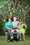 Family sit on white bench with bunch of flowers