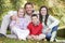 Family sitting amongst autumn trees