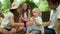 Family sitting on blanket in park. Adorable toddler drinking water from bottle