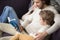 Family sitting on couch at home with a book