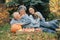 Family sitting in a garden with apples and pumpkin