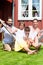 Family sitting in hammock in front of home