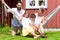 Family sitting in hammock in front of home