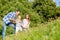 Family sitting on meadow with child waving hands