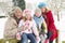 Family Sitting In Snowy Landscape