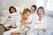 Family sitting on sofa while mother reads book