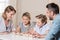 Family sitting at table, word family by wooden brick