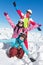 Family ski vacation in winter sports. Three young girls posing in the snow and the blue sky, and raising their hands