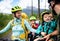 Family with small children cycling outdoors in summer nature.