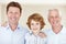 Family smiles. Cropped portrait of a young boy standing with his father and grandfather.