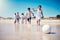 Family soccer, beach holiday and kids running by the sea with happiness and freedom. Football, young girl and parents