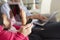 Family On Sofa With Smartphone, Laptop And Digital Tablet