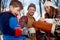 Family with son enjoying playing in fresh snow during wintertime and having hot chocolate during a picnic