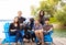 Family with special needs child sitting outdoors together in sum