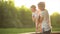 Family spends time in nature. mother tenderly embracing daughter, beautiful mom playing with her children in the park