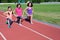 Family sport and fitness, happy mother and kids exercising and running on stadium track outdoors, active children