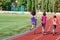 Family sport and fitness, happy mother and kids running on stadium track outdoors, children healthy active lifestyle