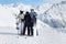 Family stand with snowboard and skis on mountain