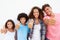 Family Standing Outdoors Against White Wall Giving Thumbs Up