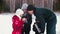 Family standing outdoors at winter - drinking hot drinks from the thermos