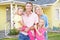 Family Standing Outside Suburban Home