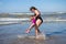 Family are on summer sea vacation. Mother and daughter swimming in sea water. Young woman and child splashing in sea