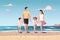 Family on summer vacation concept. Parents couple and kids walking on beach.