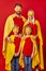 Family of superheroes in costumes posing in studio with red background