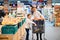 Family in the supermarket. Beautiful young mom and her little daughter smiling and buying food. The concept of healthy eating.