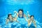 Family swim in pool underwater, mother and children have fun in water,