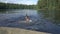 Family swimming in a forest lake in Finland