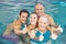 Family in swimming pool holding